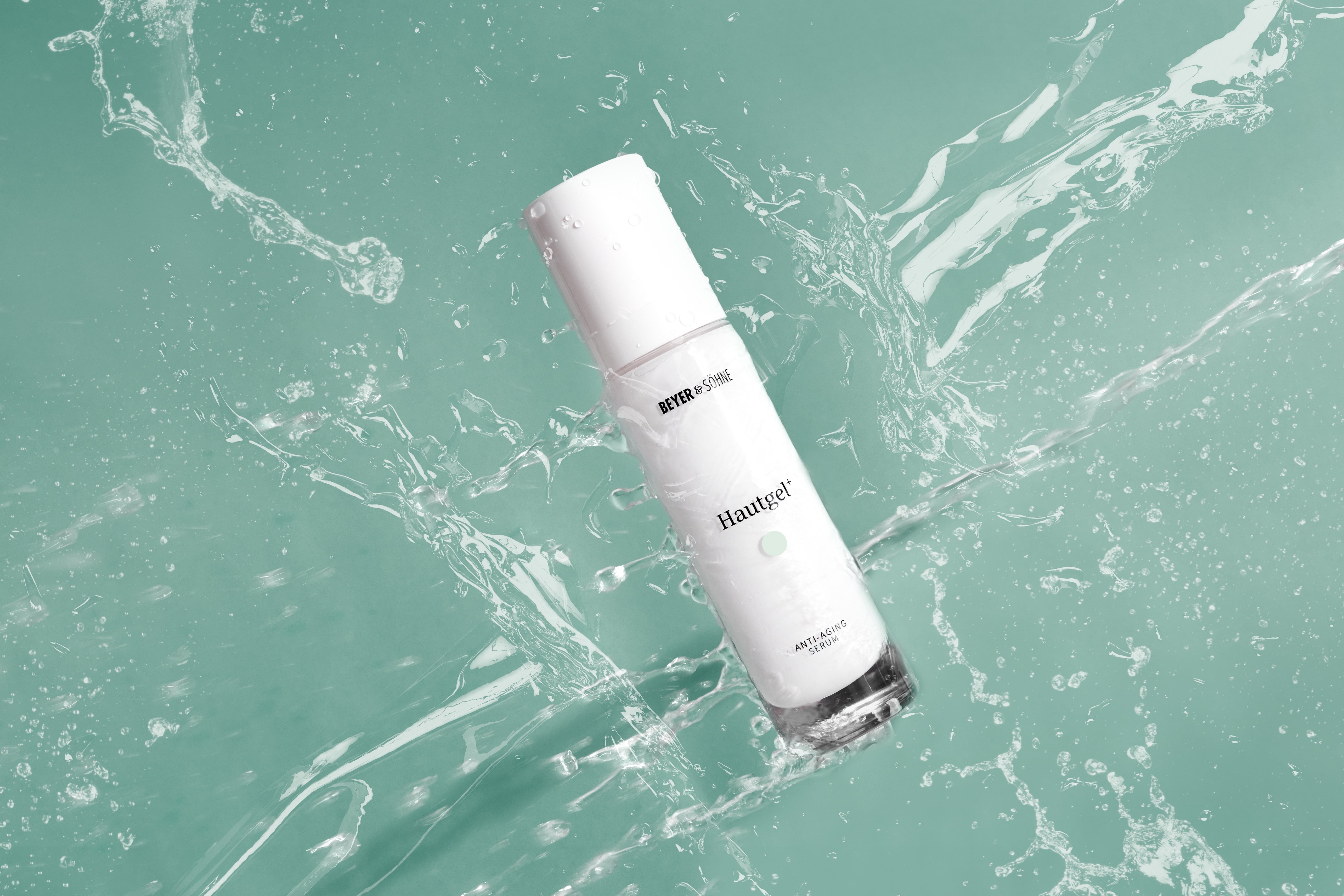 Hautgel Anti-Aging Serum im Wasserstrahl auf türkisfarbenem Hintergrund